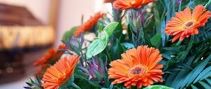 A close up of some orange funeral floral arrangements, available as part of the Selsdon & District funeral floristry services.