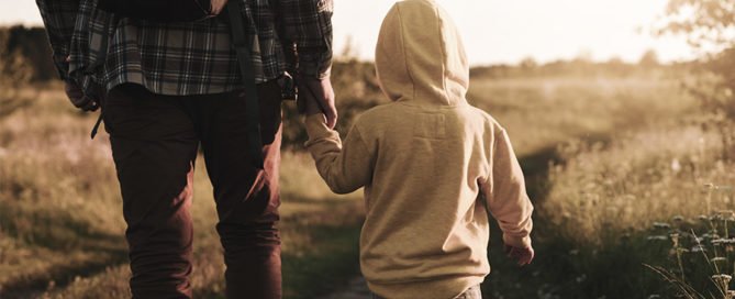 An image of a father holding his son's hand.